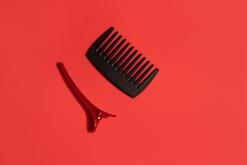 
Hair clip and a comb on red background
