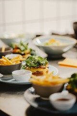 Vertical closeup shot of a gourmet burger being prepared at a restaurant table