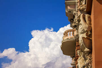 Fototapeta na wymiar dessus de porte, sculptures on a house against a sky with clouds