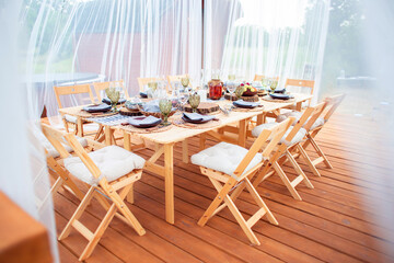 Table setting in the open air for a large company. Meals on the outdoor terrace of the restaurant