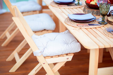 Beautiful eco-friendly wooden furniture on the summer terrace of the restaurant. Folding chairs for...