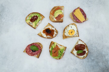 Variety of tapas sandwiches for aperetif on gray background. Top view.