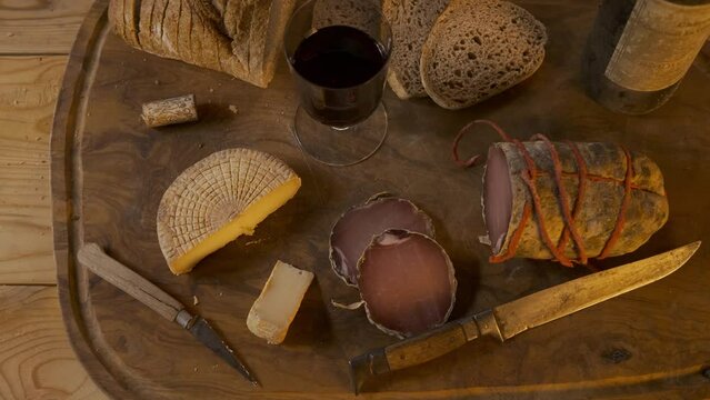 Charcuterie, fromage, pain avec vin rouge et des couteaux sur une planche en bois d'olivier pour ap&eacute;ritif fran&ccedil;ais