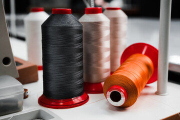 multi-colored bobbins with threads for sewing shoes at a large industrial plant close-up