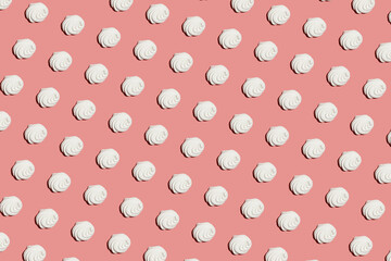 A hard light pattern of a sweet meringue dessert pavlova on a bright colorful pink seamless background, top view