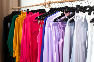 clothes at store - different apparel on hangers, bright and colorful silk shirts