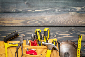 Meter, wooden planks, construction tools and circular saw blade on the carpenter workbench flat lay...