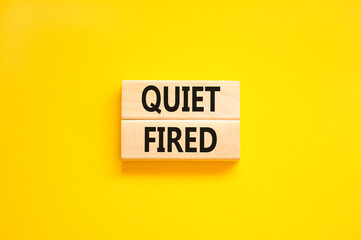 Quiet fired symbol. Concept words Quiet fired on wooden blocks. Beautiful yellow table yellow background. Business and quiet fired concept. Copy space.