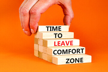 Leave comfort zone symbol. Concept words Time to leave comfort zone on wooden blocks. Businessman hand. Beautiful orange background. Business time to leave comfort zone concept. Copy space.