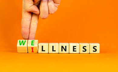 Wellness or illness symbol. Concept words Wellness and Illness on wooden cubes. Doctor hand. Beautiful orange table orange background. Medical healthy lifestyle wellness or illness concept. Copy space