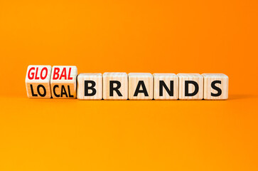 Global or local brands symbol. Concept words Global brands and Local brands on wooden cubes. Beautiful orange table orange background. Business global or local brand concept. Copy space.