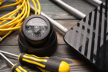 Security camera, wifi router and screwdrivers on the table close up background. Video surveillance...