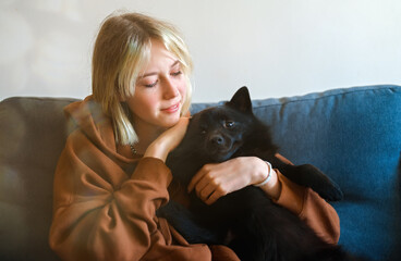 Teenage girl with cute Schipperke dog.
