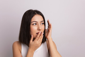 Fototapeta premium beauty portrait of a beautiful cheerful young oriental woman in a white T-shirt in the studio on a white wall. make-up artist and hairdresser hairdresser in a beauty salon.