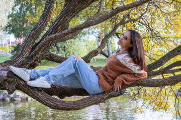 A girl is dotting on a tree branch