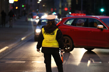  Policjant drogówki kieruje ruchem samochodów w mieście. - obrazy, fototapety, plakaty