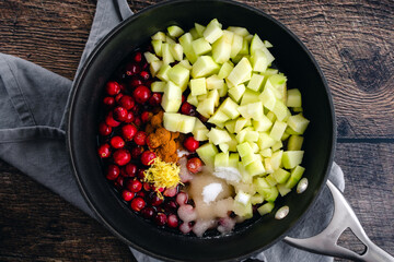 Apple Cranberry Sauce with Cider & Cinnamon Ingredients in a Saucepan: Overhead view of raw cranberry sauce ingredients in a small pot