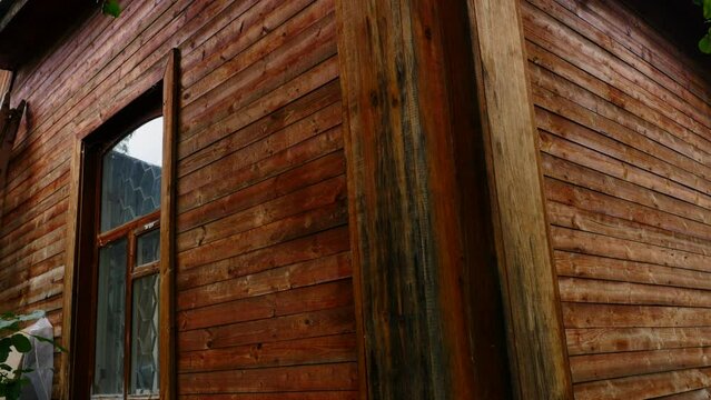 Exterior of a wooden house in the countryside. Stock footage. Traditional residential house with wooden walls.