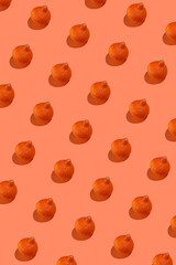 A hard light pattern of a small yellow and orange decorative pumpkin on a bright orange seamless background,