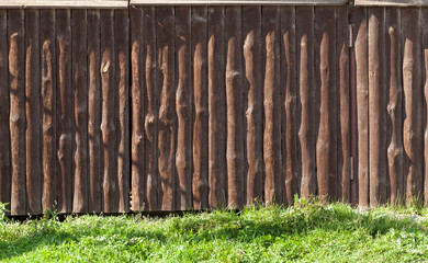 Wooden fence and green grass on a sunny day