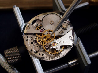 close up pic of watchmaker repairing vintage watch mechanism