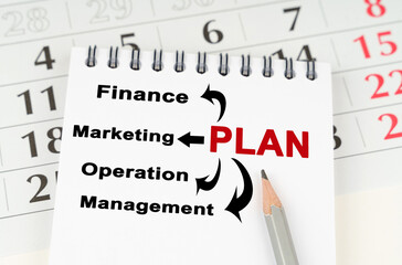 On the calendar is a notebook with the inscription - Plan Finance Marketing Operation Management