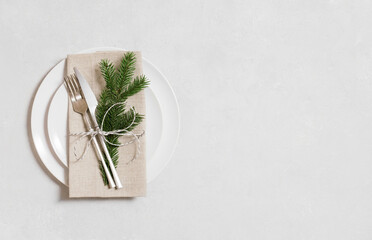 Christmas table setting with silver cutlery and fir branch on a gray background. Copy space, top...
