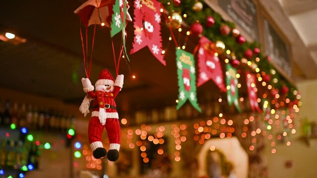 toy snowman on a parachute against the background of Christmas lights