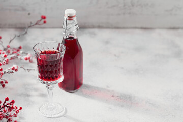 Homemade infused vodka, tincture or liqueur of red cherry on white background. Berry alcoholic...