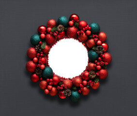 Christmas wreath with cones, red baubles and berries on a gray background. Copy space, top view, flat lay.