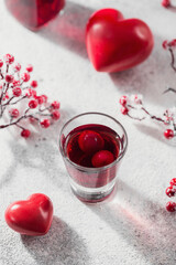 Red cocktail, vodka or liqueur and Heart shape decorations on white background. Happy Valentines day concept.