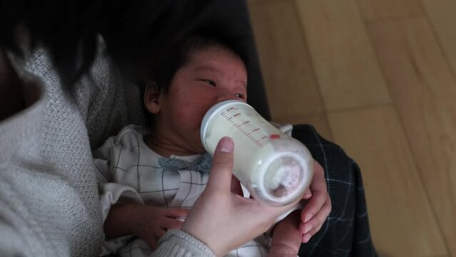 産後1か月0歳の新生児に母親がミルクをあげる様子を上から撮影した動画