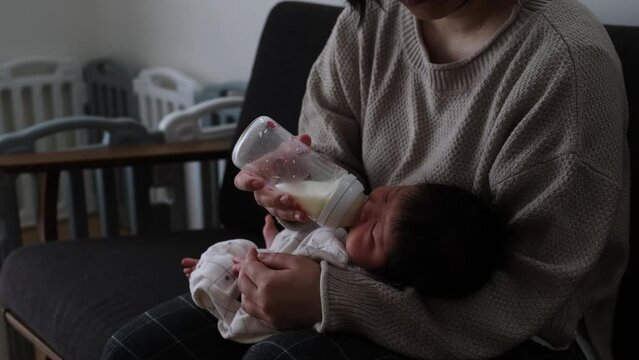 産後1か月0歳の新生児に母親がミルクをあげる様子を横から撮影した動画