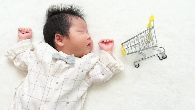 産後1か月0歳の新生児の横に買い物のカートを配置した動画