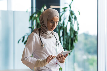 A worried and serious female doctor, an Arab, a Muslim, is standing in the corridor of the...