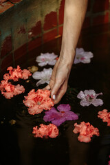 Beautiful brunette in a garden of azaleas in a green dress