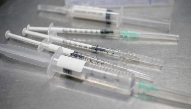 On the table are a lot of syringes filled with medicines. Syringes of different sizes and volumes. Syringes are drawn for injection to the patient.