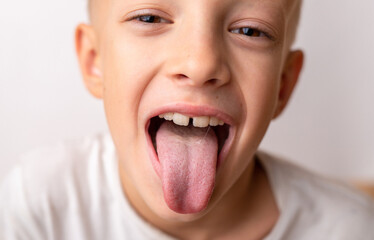 Close-up smile of a little happy child of 8 years old who shows the tongue