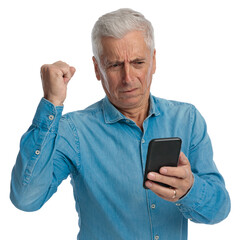 old man holding telephone, reading news and celebrating with fist up
