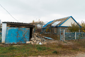 Fototapeta na wymiar Countryside. House destroyed by shelling. War in Ukraine. Russian invasion of Ukraine. Destruction of infrastructure. Terror of the civilian population. War crimes