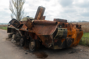 Countryside. After the battle. Destroyed burnt combat vehicle stands on the side of the road. War in Ukraine. Russian invasion of Ukraine