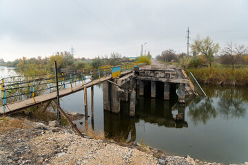 Destroyed bridge across the river. War in Ukraine. Russian invasion of Ukraine. Destruction of...