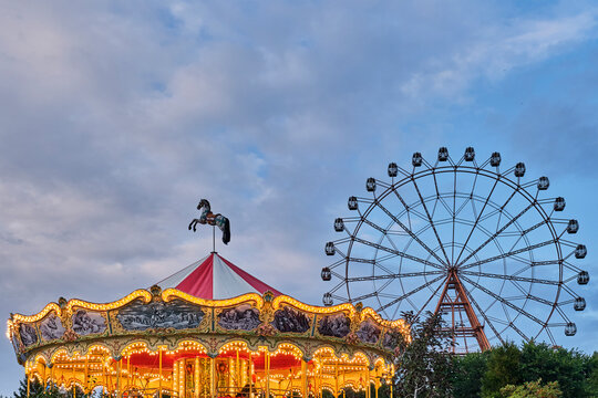 The dome of a children's carousel in a retro style. Evening amusement park.