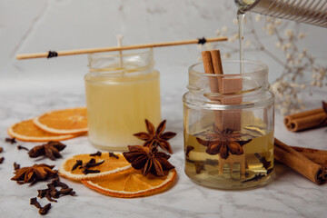 Liquid soy candle wax is poured into a glass jar. Crafting and handmade. Eco friendly decorative element.Close up.