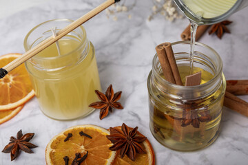 Liquid soy candle wax is poured into a glass jar. Crafting and handmade. Eco friendly decorative element.Close up.