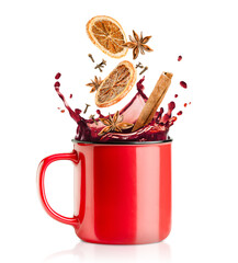 a splash of mulled wine, falling into a red mug of cinnamon, cloves, dried orange and anise on a...