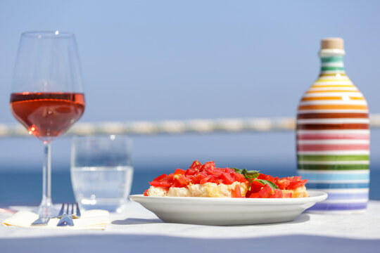 Frisa, frisella, pane e pomodoro con bicchiere di vino vista mare