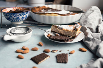 Homemade cheesecake with sugar and chocolate on a plate. Piece of cake for christmas on a table in the kitchen. Traditional food. Closeup