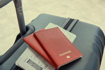 Two passports and plane tickets on the luggage suitcase in airport