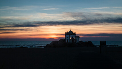 View of the Chapel Senhor da Pedra at night in Miramar Beach, Porto, Portugal.